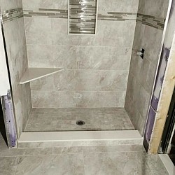Small bath,  Tile floor,with tile 12x12 in showers mosaic 2x2  desing, with curve marmol,  Walls tile, 12x24 inches, with nice corner bench, and border mosaic, around with shampo Box .